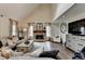 Bright, stylish living room featuring a stone fireplace, high ceilings, and hardwood floors at 443 Lakeshore Dr, Berkeley Lake, GA 30096