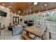 Inviting covered porch features a dining area and relaxing seating around a coffee table at 443 Lakeshore Dr, Berkeley Lake, GA 30096