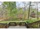 Beautiful view of the pond from the wooden deck with railings offering a serene outdoor space at 443 Lakeshore Dr, Berkeley Lake, GA 30096