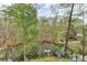 Scenic view of a private pond with a dock surrounded by lush greenery and mature trees at 443 Lakeshore Dr, Berkeley Lake, GA 30096