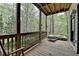 Inviting porch featuring a hot tub and a rocking chair, perfect for relaxation amidst nature at 443 Lakeshore Dr, Berkeley Lake, GA 30096