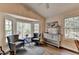 Sitting area features comfortable seating and large windows overlooking the surrounding greenery at 443 Lakeshore Dr, Berkeley Lake, GA 30096