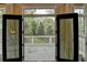 View through the French doors onto the outdoor deck with white railings and wooded landscape at 443 Lakeshore Dr, Berkeley Lake, GA 30096
