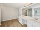 Bathroom featuring double vanity, a large mirror, wood flooring, and a glass-enclosed shower at 172 Mill Creek Dr, Canton, GA 30115