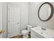 Half bathroom with modern fixtures, a round mirror, and a vanity sink at 172 Mill Creek Dr, Canton, GA 30115