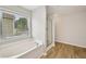 Bright bathroom with a soaking tub and shower with wood-look floors at 172 Mill Creek Dr, Canton, GA 30115