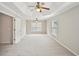 Spacious bedroom with tray ceiling, ceiling fan, and plush carpet, perfect for relaxation at 172 Mill Creek Dr, Canton, GA 30115