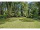 Large backyard featuring a lush green lawn and mature trees at 2447 Crestview Ave, Decatur, GA 30032