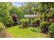 Landscaped backyard with mature trees, green grass, and a glimpse of the home at 295 Glen Lake Dr, Atlanta, GA 30327