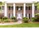 Up close image showing brick exterior, columns, trimmed shrubs, and front door at 295 Glen Lake Dr, Atlanta, GA 30327