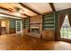 Open-concept living room featuring exposed wood beams, brick fireplace, and custom built-in shelving at 295 Glen Lake Dr, Atlanta, GA 30327