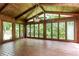 Bright sunroom with wood paneling, vaulted ceiling, terracotta flooring, and walls of windows at 295 Glen Lake Dr, Atlanta, GA 30327