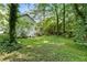 Green backyard with lawn and landscaping and a partial view of the house at 411 Woodstone West Dr, Marietta, GA 30068
