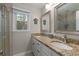 Bright bathroom featuring double vanity, granite countertops, decorative mirrors and glass shower at 411 Woodstone West Dr, Marietta, GA 30068