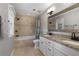 Bathroom featuring double vanity, granite countertops, decorative mirror and tiled bath at 411 Woodstone West Dr, Marietta, GA 30068