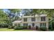Traditional two-story home with a welcoming front porch and a well-maintained lawn with mature trees at 411 Woodstone West Dr, Marietta, GA 30068