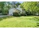 Well-maintained house with a green lawn and a paved driveway leading to the garage at 411 Woodstone West Dr, Marietta, GA 30068