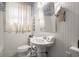 White bathroom with pedestal sink, decorative mirror and tiled floors at 1791 Melrose Sw Dr, Atlanta, GA 30310