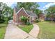 Cozy brick home with a curved roofline, arched entryway, detached garage, and driveway at 1791 Melrose Sw Dr, Atlanta, GA 30310