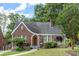 Charming brick home with a curved roofline, arched entryway, and lush landscaping at 1791 Melrose Sw Dr, Atlanta, GA 30310