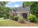 Quaint brick home with a curved roofline, arched entryway, screened in porch, and green lawn at 1791 Melrose Sw Dr, Atlanta, GA 30310