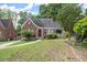 Charming brick home with a curved roofline, arched entryway, and lush landscaping at 1791 Melrose Sw Dr, Atlanta, GA 30310