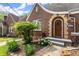Charming brick home with an arched entryway, lush landscaping, and flowering plants at 1791 Melrose Sw Dr, Atlanta, GA 30310