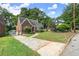 Brick home with a curved roofline, arched entryway, driveway, and lawn with mature trees at 1791 Melrose Sw Dr, Atlanta, GA 30310