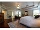 Large primary bedroom with hardwood floors, ceiling fan, and view of en suite bath at 120 Clifford Ct, Canton, GA 30115