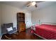 Bedroom with red bedspread, bookshelf, rocking chair and wood floors at 120 Clifford Ct, Canton, GA 30115