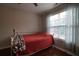 Bedroom boasts a bright window, ceiling fan and hardwood floors with a cozy bed and colorful throw at 120 Clifford Ct, Canton, GA 30115