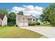 View of the house from a corner of the yard showing the two-car garage and green lawn at 4015 Soaring Dr, Douglasville, GA 30135