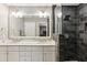 Modern bathroom features a dual sink vanity with a marble countertop and a frameless glass shower with dark tiling at 3005 Howell Mill Rd, Atlanta, GA 30327