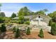 Charming home exterior with a two-car garage, circular driveway, and meticulously landscaped front yard at 3005 Howell Mill Rd, Atlanta, GA 30327