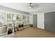 Bright living room with large windows, modern ceiling fan, and unique painted brick feature wall offers style and comfort at 3005 Howell Mill Rd, Atlanta, GA 30327