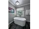 Bathroom featuring a modern tub with a window view of the lush green yard at 3075 Nuthatch Nw Ct, Kennesaw, GA 30144