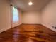 A bedroom featuring hardwood floors and a window with sheer curtains at 3075 Nuthatch Nw Ct, Kennesaw, GA 30144