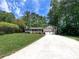 Traditional home with a well-manicured lawn, front porch, and long driveway leading to a two-car garage at 3075 Nuthatch Nw Ct, Kennesaw, GA 30144
