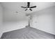 An empty bedroom with freshly painted gray walls, gray carpet, and a ceiling fan with light and two doors at 2246 Hightrail Ct, Lithonia, GA 30058