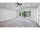 An empty bedroom with freshly painted gray walls, gray carpet, and a ceiling fan with light and bay windows at 2246 Hightrail Ct, Lithonia, GA 30058