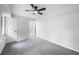 An empty bedroom with freshly painted gray walls, gray carpet, with two doors and a ceiling fan with light at 2246 Hightrail Ct, Lithonia, GA 30058