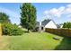 Picture of a large fenced backyard with a covered patio, lawn, and mature trees at 2487 Battery Pointe, Lawrenceville, GA 30043