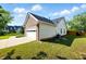 View of the side of the home showing the garage, lawn, and siding at 2487 Battery Pointe, Lawrenceville, GA 30043