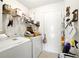 Functional laundry room with washer, dryer, storage shelves, and a convenient utility sink at 2487 Battery Pointe, Lawrenceville, GA 30043