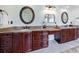 Bathroom features a double vanity with granite countertop, dark wood cabinets, and decorative mirrors at 510 Belada Blvd, Atlanta, GA 30342