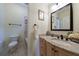Bathroom featuring a granite vanity, framed mirror, and tub with tile surround at 510 Belada Blvd, Atlanta, GA 30342