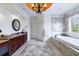 This bathroom offers a soaking tub, decorative window, wood cabinets, granite counters, and tile floors at 510 Belada Blvd, Atlanta, GA 30342