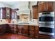 Well-equipped kitchen with dark wood cabinets, a custom range hood, and stainless steel double ovens at 510 Belada Blvd, Atlanta, GA 30342