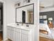 A bathroom featuring a double vanity, a walk-in shower, and a view into the adjacent bedroom at 732 Province Se Pl, Atlanta, GA 30312