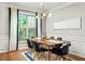 Bright dining room with modern lighting, a wooden table set for six, and large window with serene backyard view at 732 Province Se Pl, Atlanta, GA 30312